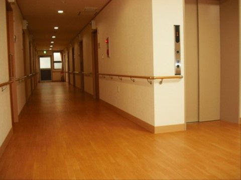 通路は長く、横幅もあるため、車椅子をご利用の方も通行しやすくなっている。壁の両側には手すりがある。壁には火災報知器もある。