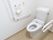 清潔感あふれる真っ白なトイレである。温水洗浄便座やナースコール、手すり、立ち座りの支えとなるバーが完備されている。