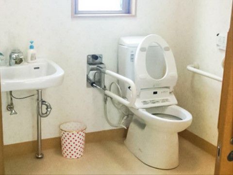 トイレの中には洗面台が備え付けられている。手すりも設置されているため、足腰の弱い入居者様も安心して使用できる。