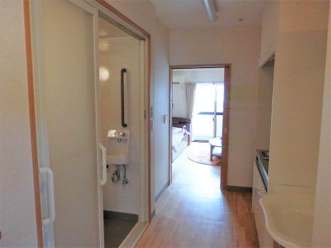 木目が感じられるフローリングで、肌触りが良い室内である。トイレの室内には、壁と異なるカラーの手すりを取り付け安全性にも十分配慮している。