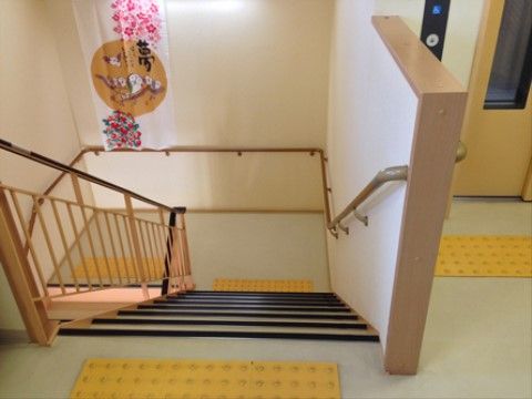 「みのりグループホーム平野」の階段。床に点字ブロックが敷設されている。