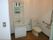 居室のトイレにはＬ字型の手すりがついており、すぐ横には洗面台がある。洗面台には鏡や棚、収納スペースがある。