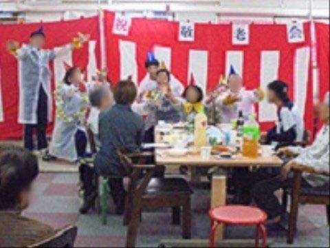 敬老会のイベントで職員のダンスを楽しげに観覧する入居者