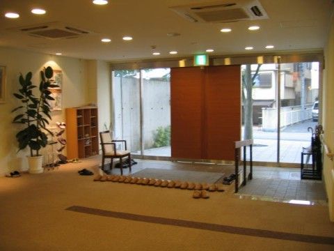 木製の両開きの自動ドアと、手すりが備えられた広く明るい玄関
