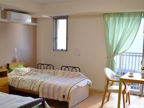 夫婦での入居も可能な２人部屋タイプの居室である。優しい色合いの壁紙と木目調の床が息苦しさを感じさせない。