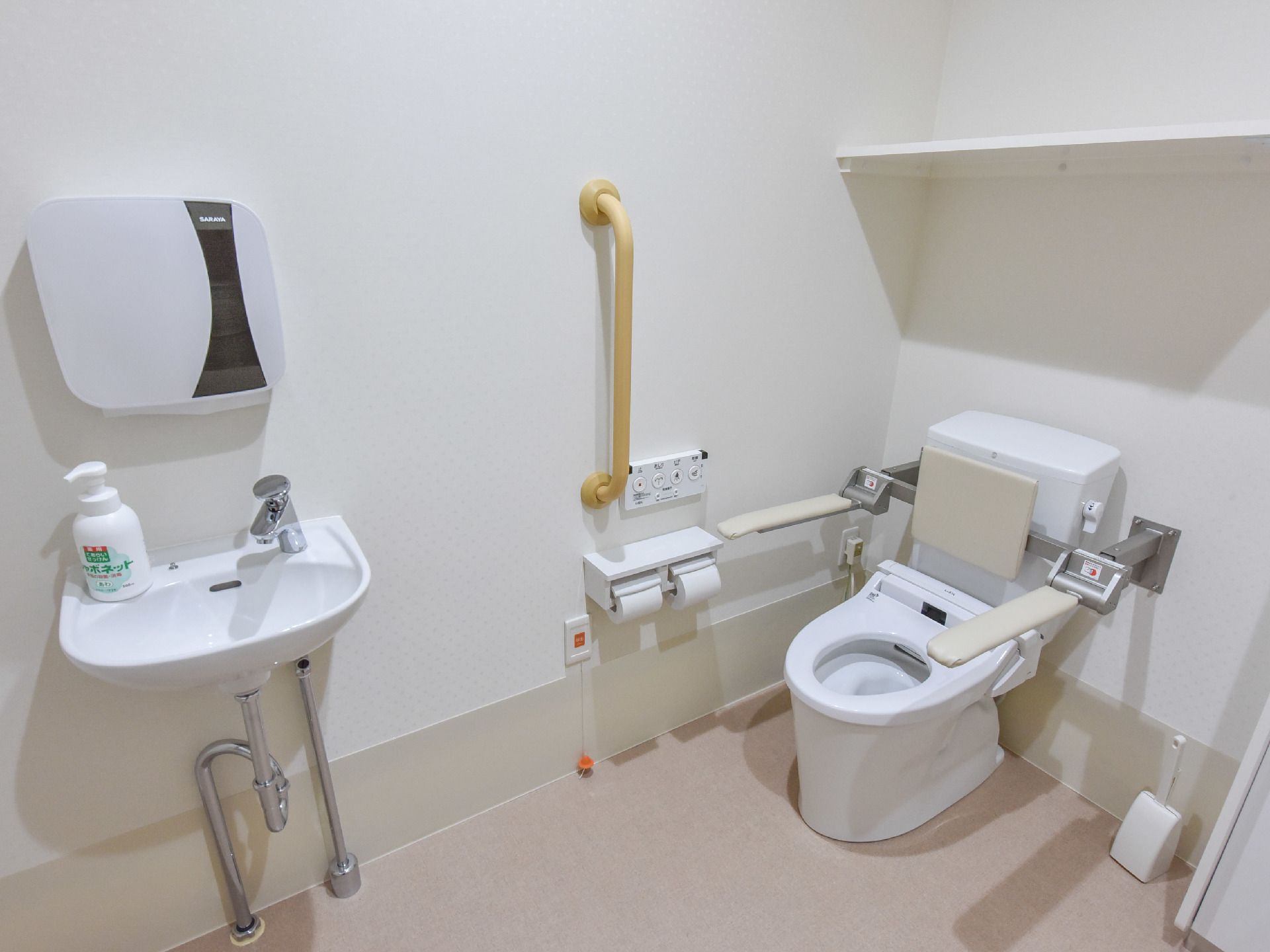 トイレスペースには右の壁際に洋式便器、左側に手洗いが設置されている。ボウルの上部にはペーパータオルホルダーがある。