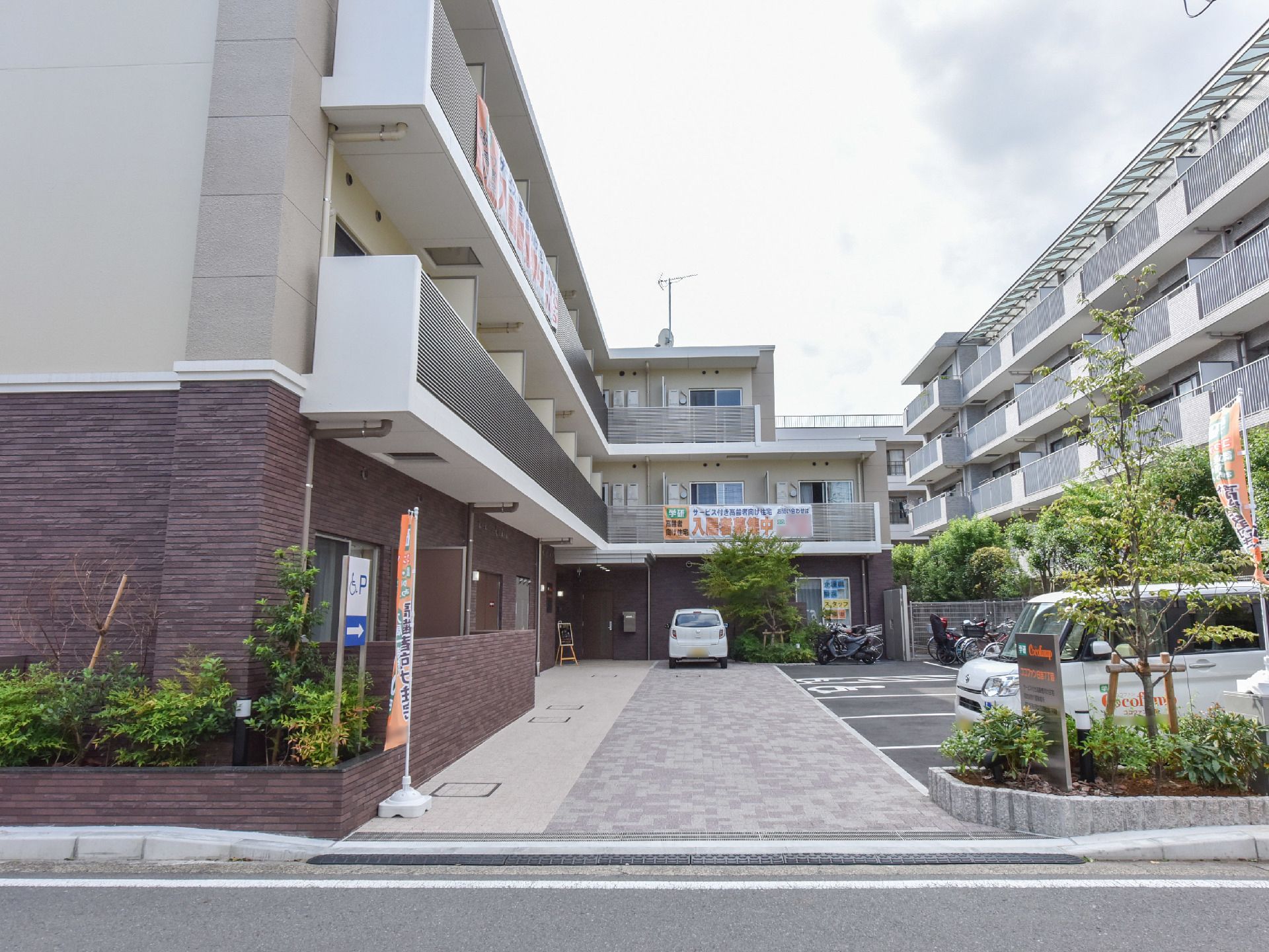 中央奥に向かって駐車スペースが５台分ある３階建てのマンションのような施設