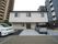白色を基調とした外壁の２階建ての施設である。玄関のすぐ前が駐車スペースになっていて、車が２台停まっている。