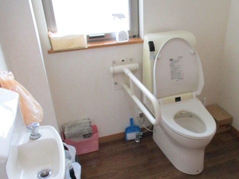 トイレはスペースは広めになっており、床面は段差がない。洋式便器が設置されており、便器脇に手すりが付いている。手洗い場もある。