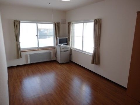 2方向に窓があり、テレビや暖房が完備された洋間