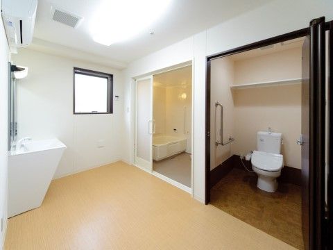 手前のスペースに大型の洗面台があり、奥側の壁にトイレと浴室のドアがある。どちらのドアも大きく開き、中のスペースも広く取られている。