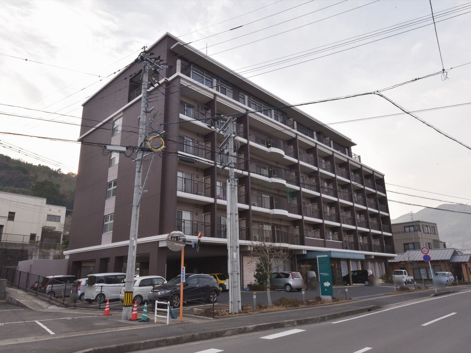 施設の建物は、６階建てである。それぞれの部屋にベランダが付いている。１階は駐車スペースになっている。