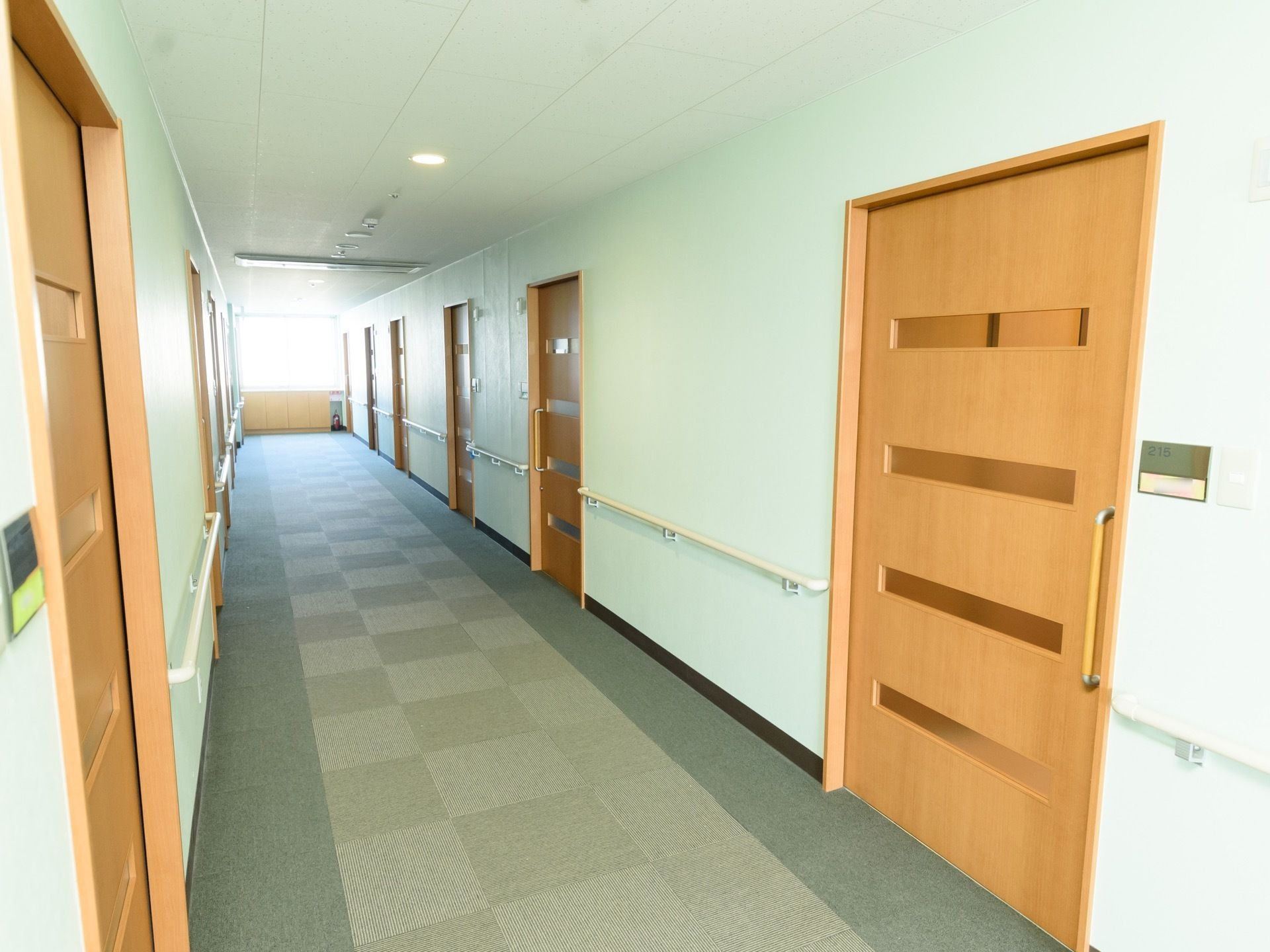 各居室の扉はスライド式となっており、横の壁には部屋番号が書かれた表札が設置されている。突き当たりには、消火器が用意されている。