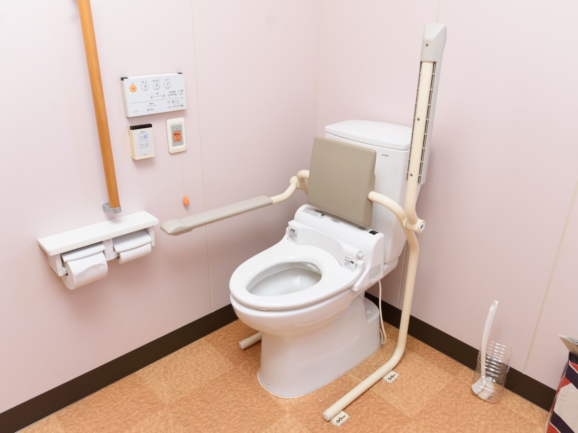白を基調とした清潔感のあるトイレ。温水洗浄機能付きとなっており、壁にはナースコールや操作パネルが設置されている。
