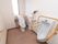 広々としたトイレには、洋式便器と男性用小便器が設置されている。手洗い用の洗面台も完備されている。窓際には棚がある。