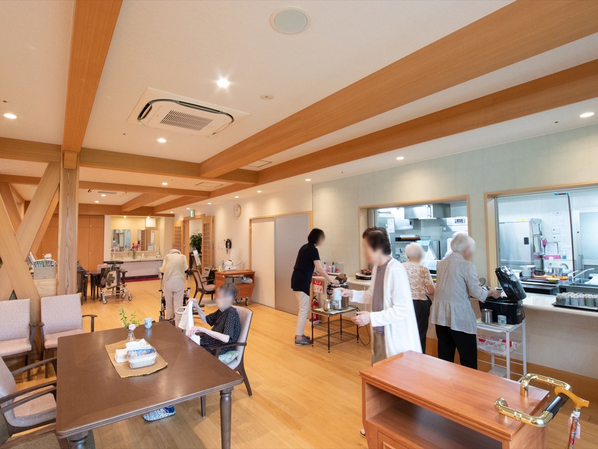 多くの入居者様が集まっており、お茶を運ばれていたりご飯をよそっていたりとそれぞれが食事の準備を行っている。