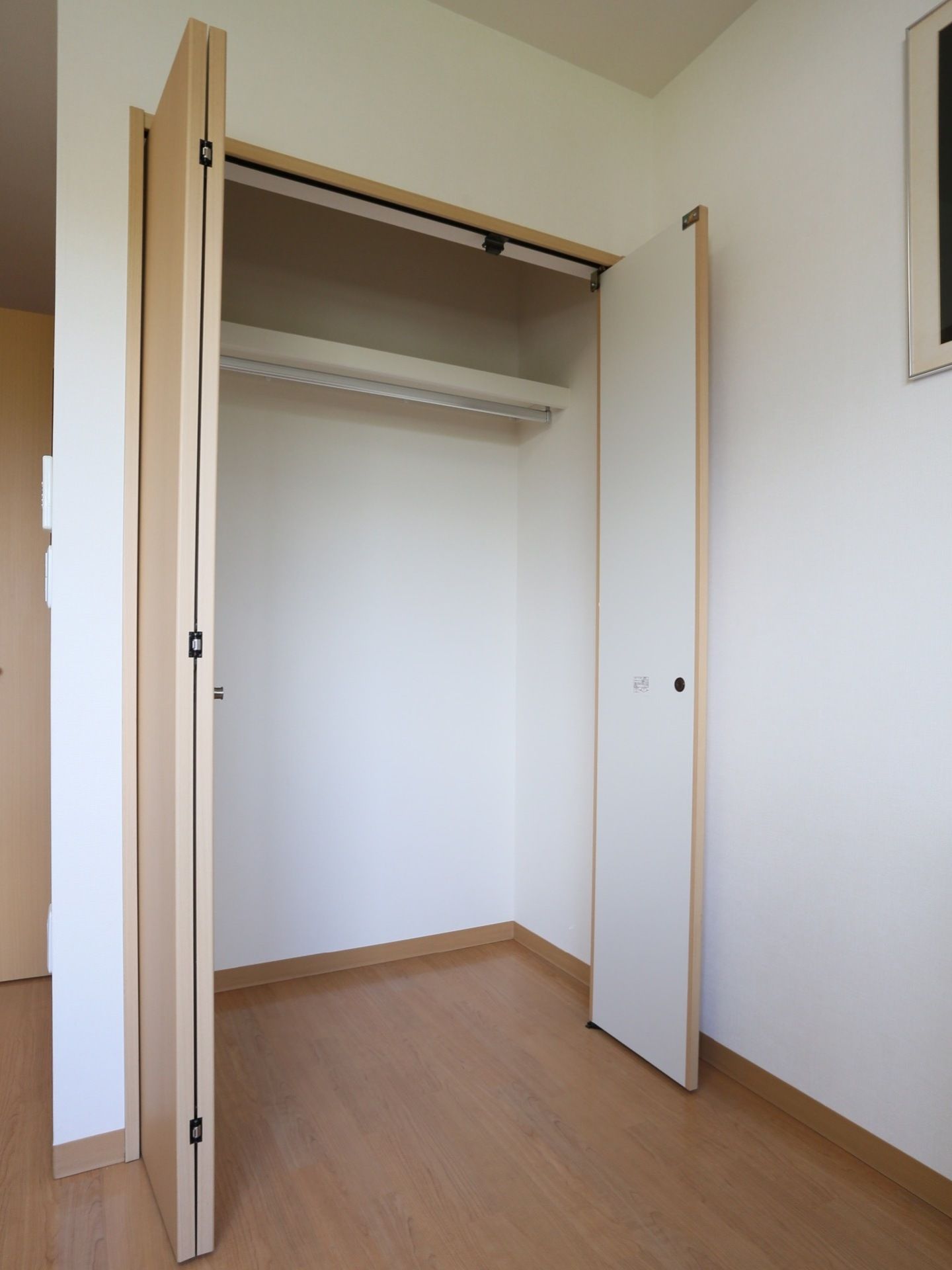 居室のクローゼットは折り畳み式の扉を採用しており、省スペースで開閉することができる。上部には棚もあるので収納力がある。