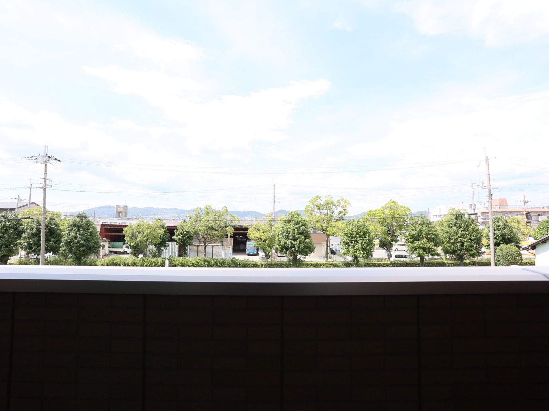 ベランダからは多くの木々が見え、施設の周りの景色を楽しむことができる。自然あふれる環境にあり、ゆったり過ごすことができる。