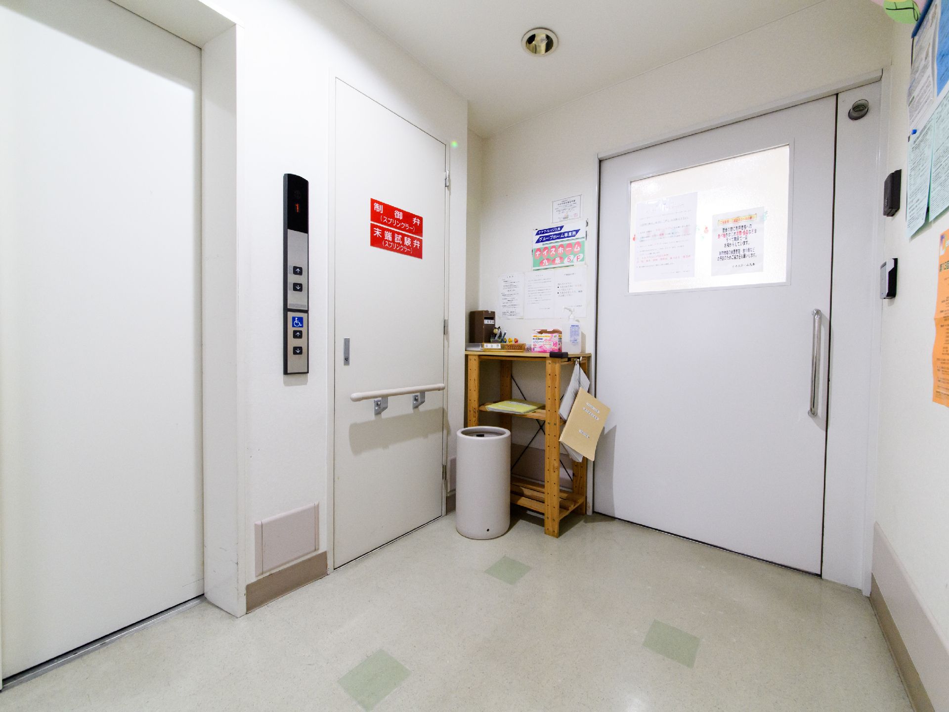 エレベーターの隣には、機械室に入る扉が設置されている。手すりも付いている。奥には、引き戸が設けられている。