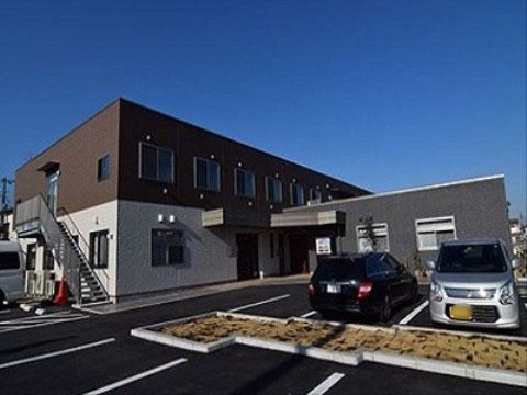 ゆったりとした駐車スペースがある茶系の色合いの２階建ての施設