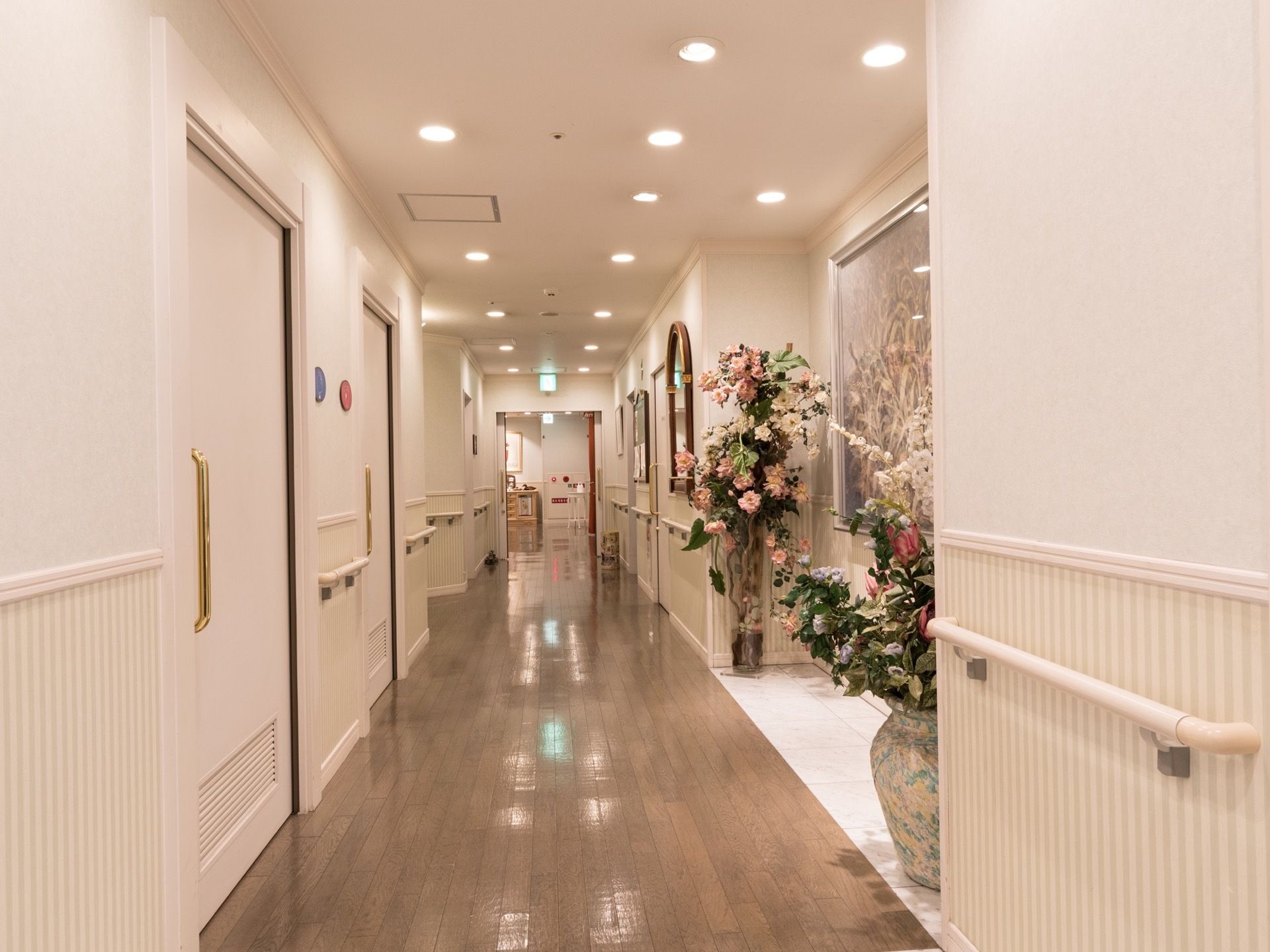 通路の両側に手すりを設置している。一角に絵画や大きな花のオブジェが飾っている。高級感がある雰囲気になっている。