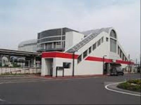 駅の建物の外観である。建物は２階建てになっており、壁の色は白色系である。スロープ設備も設置されている。
