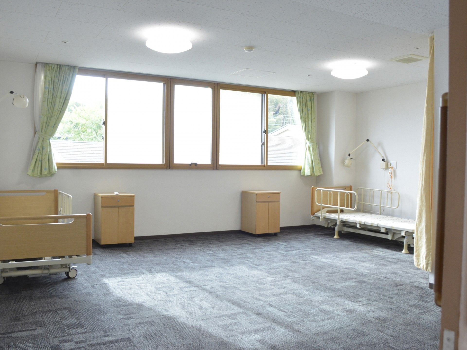 青いストラップを首から下げた男性ケアマネジャーと隣に座る高齢女性