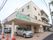 施設前には大きな屋根が取り付けられていて、その下には車が一台停められている。近くには他の車や自動販売機もある。