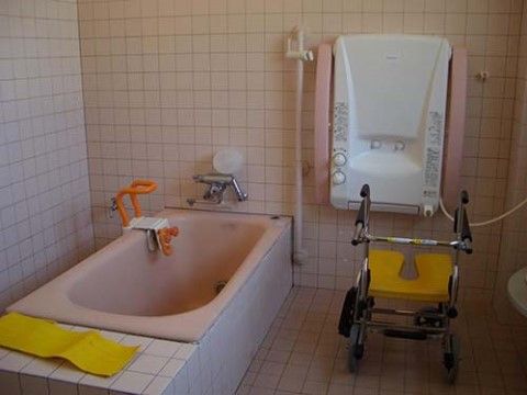 入浴機器が備え付けられている浴室である。右奥の壁に入浴機器が設置されており、その手前に車椅子状の入浴椅子が置かれている。