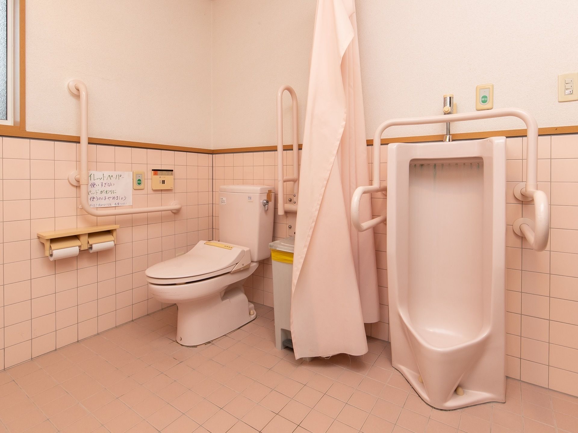 トイレ内の便座は、カーテンで仕切ることができるようになっている。手すりやつかまれる場所が用意されている。