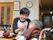 入居者様が楽しみにしている時間の一つが、お食事である。共有のスペースで、入居者様が集まって食事をする。スタッフが介助している。