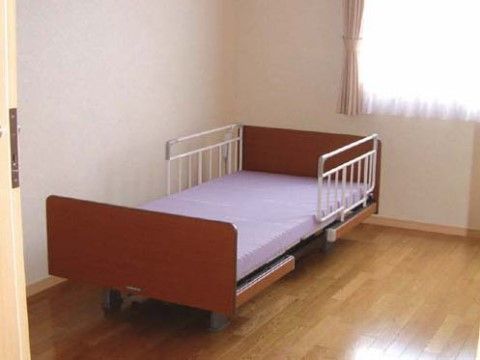 転落防止柵の付いたベッドのある、日が差すフローリングの居室
