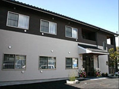 ２階建てで２色の色合いがモダンな建物である。玄関はバリアフリーで、車椅子でも不便なくご利用いただける。