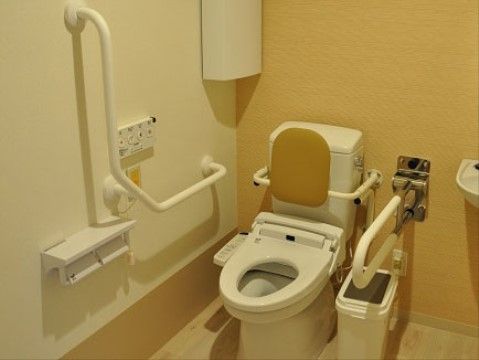 背もたれや手すりを配置しており、入居者様に快適にご利用いただけるトイレである。スペースも広く、車椅子で入っていただける。