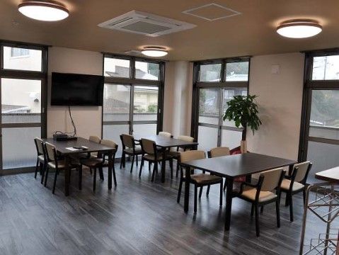 当施設ではお住まいのユニットそれぞれに食堂がある。ベランダからの日差しが入る明るく落ち着いた空間で、ゆったりとお食事していただける。