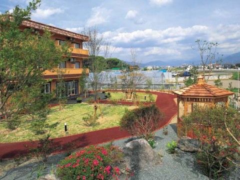 ３階建てのブラウンを基調としたグループホームである。目の前には日当たりの良い、広々とした中庭が広がっている。