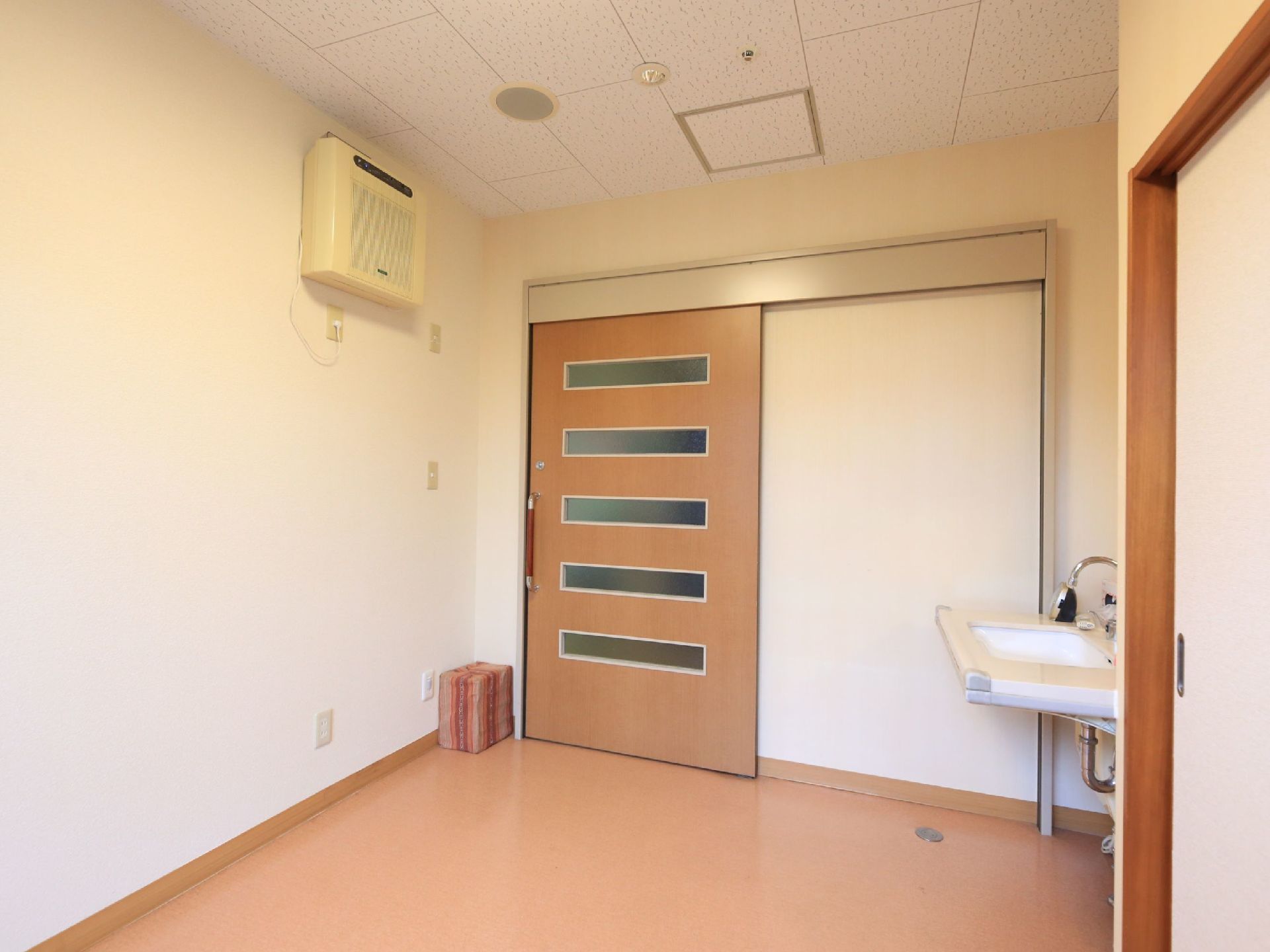 居室の入口は、横方向にすりガラスが５枚入った引き戸になっている。居室に入ってすぐの所に洗面台が設置されている。