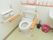 洗面台が設えられた洋式トイレである。便座の両側にひじ掛けと、壁に逆Ｌ字型のバーが備え付けらており、体を支えやすいようになっている。
