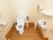 温水洗浄便座のトイレである。手洗い場も備わっており、壁には手すりとペーパーホルダーが設置されている。