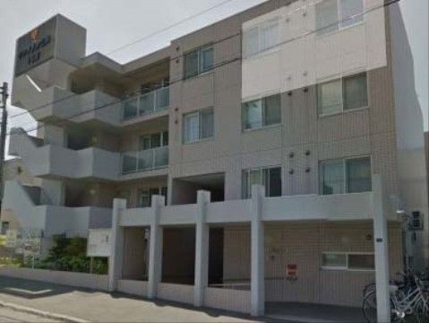 雨や風除けと堅牢な庇のある玄関が特徴の４階建ての施設
