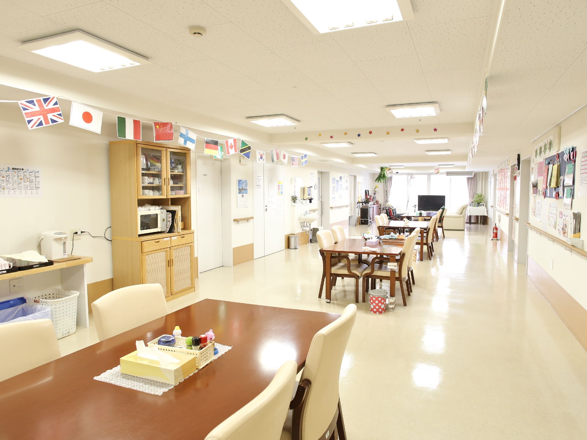 各国の国旗が飾られている。テーブルが間隔を開けて置かれている。段差のないフローリングで、広々としている。