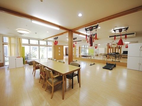 リハビリの道具が数種類と、テーブルセットが設置されているリビング