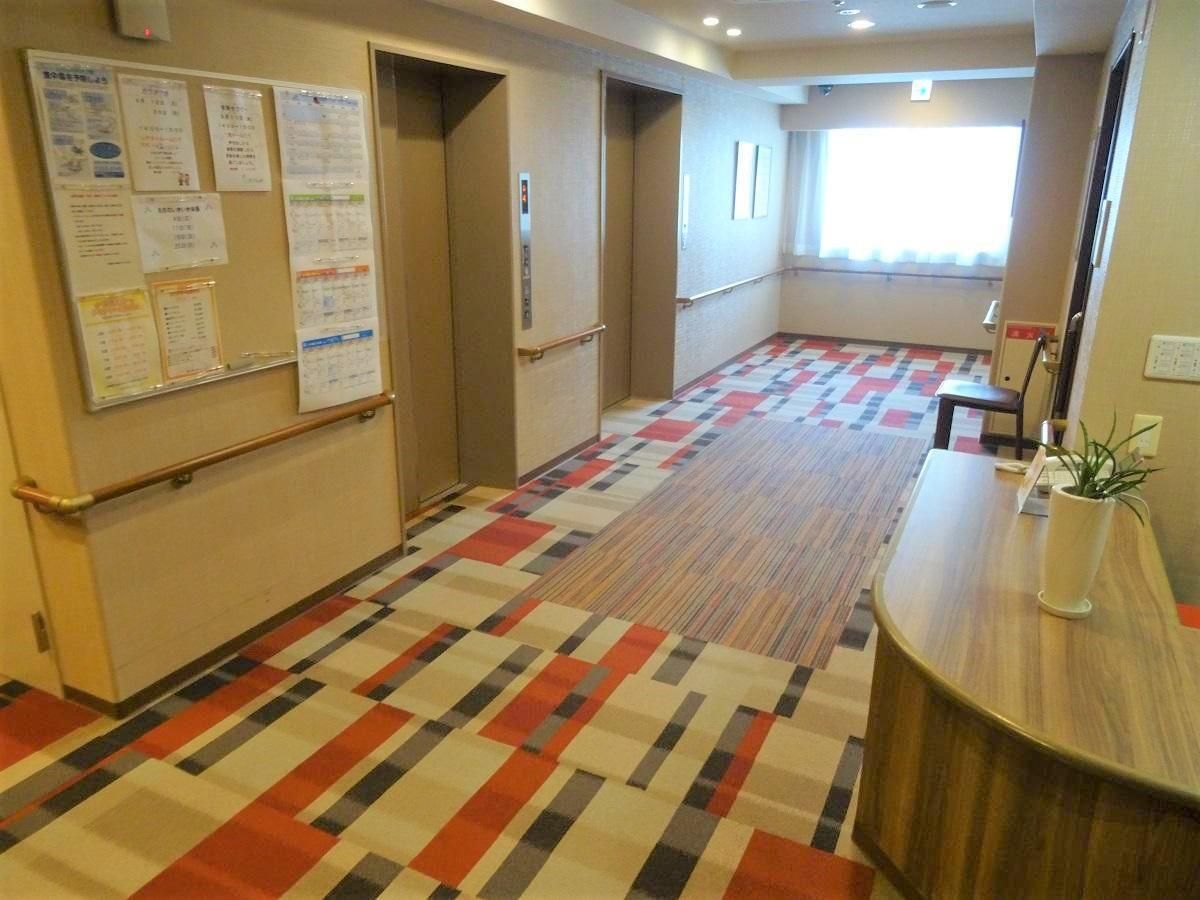 廊下はブラウン系のカラーを用いており、あたたかい色合いのライトを採用している。壁には手すりが続いており、移動に便利である。