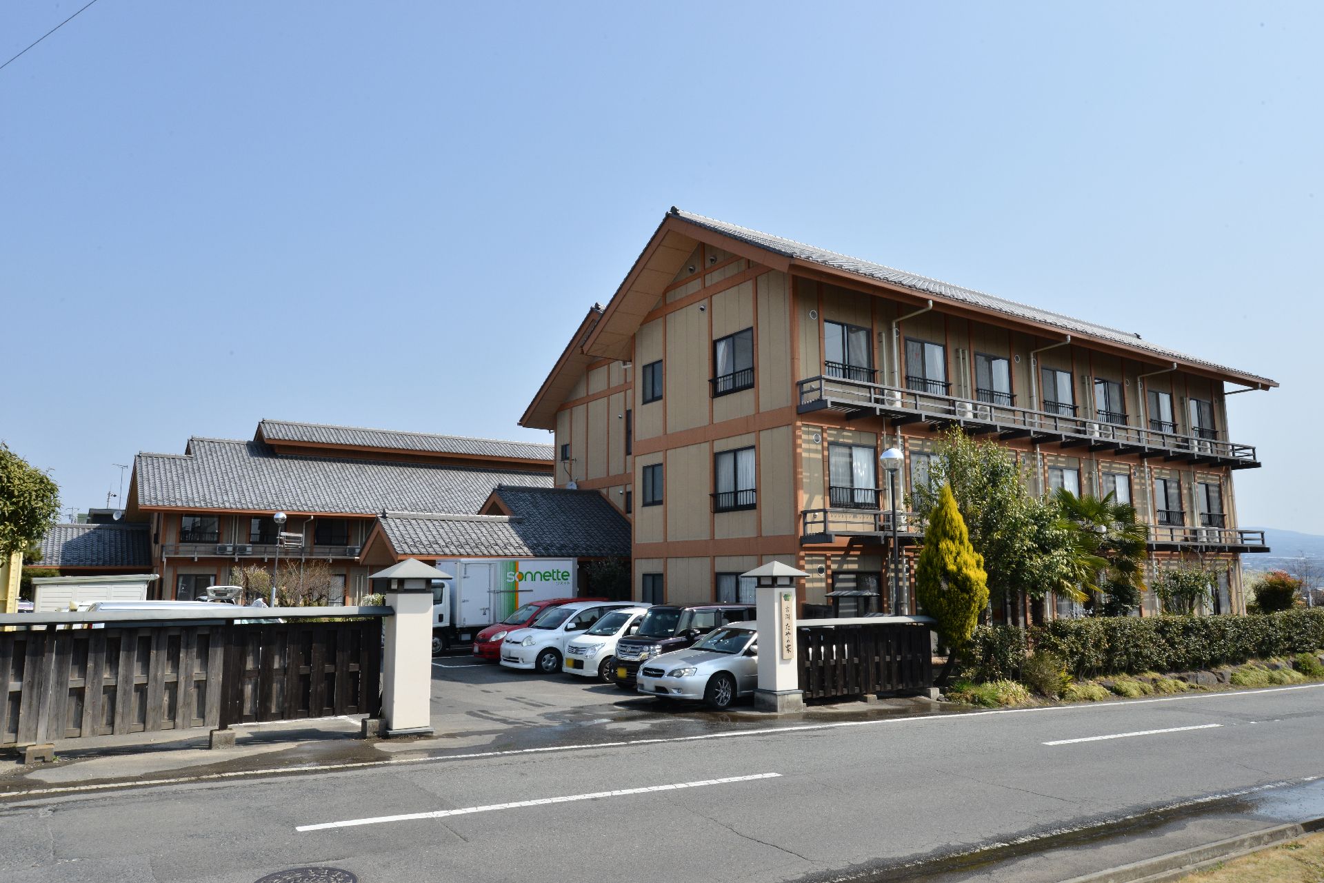 和風の老舗旅館のような造りをした、瓦屋根の三階建て施設外観