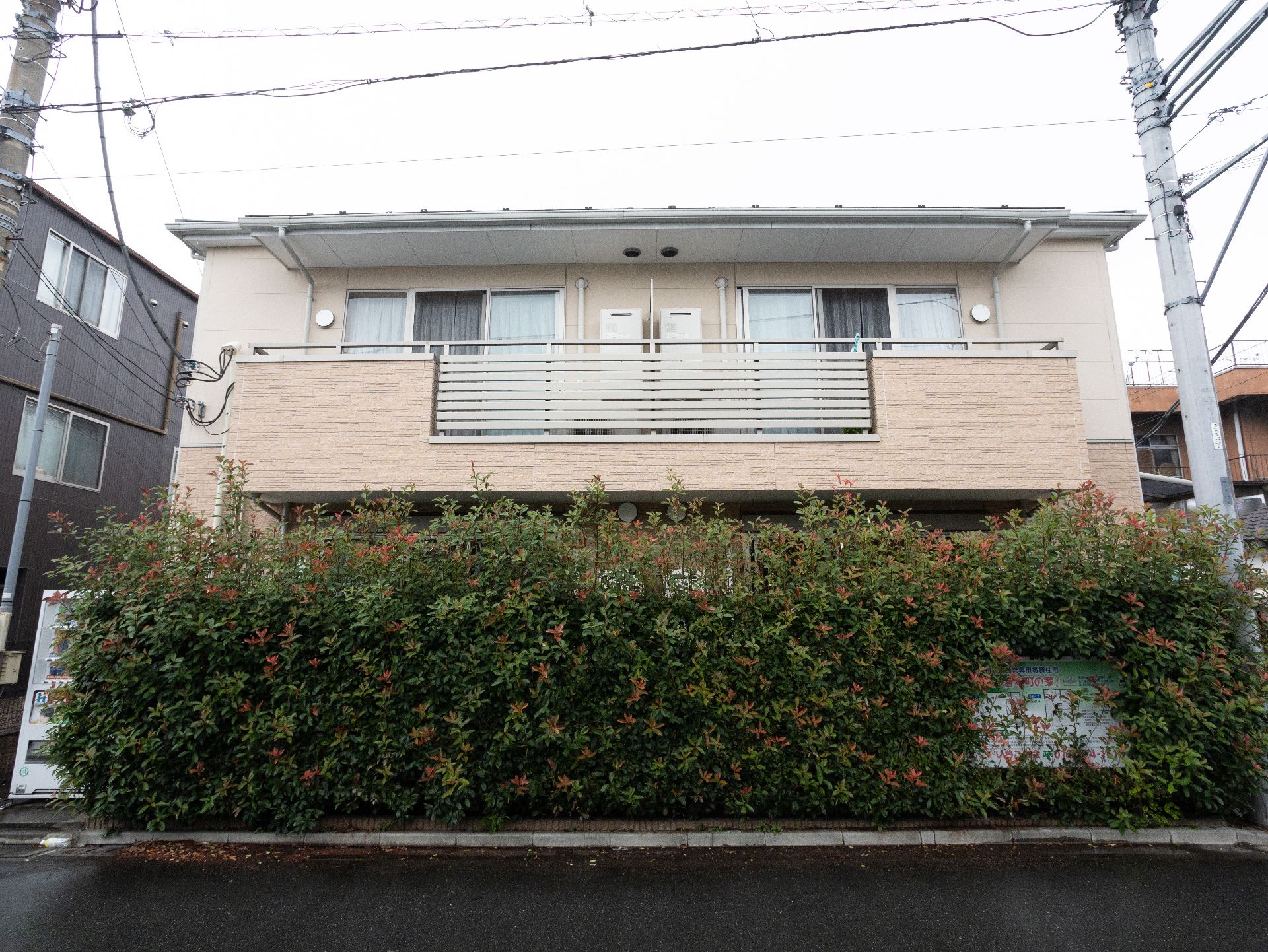 2階建てで、白と肌色の落ち着いた色合いが特徴の施設の外観