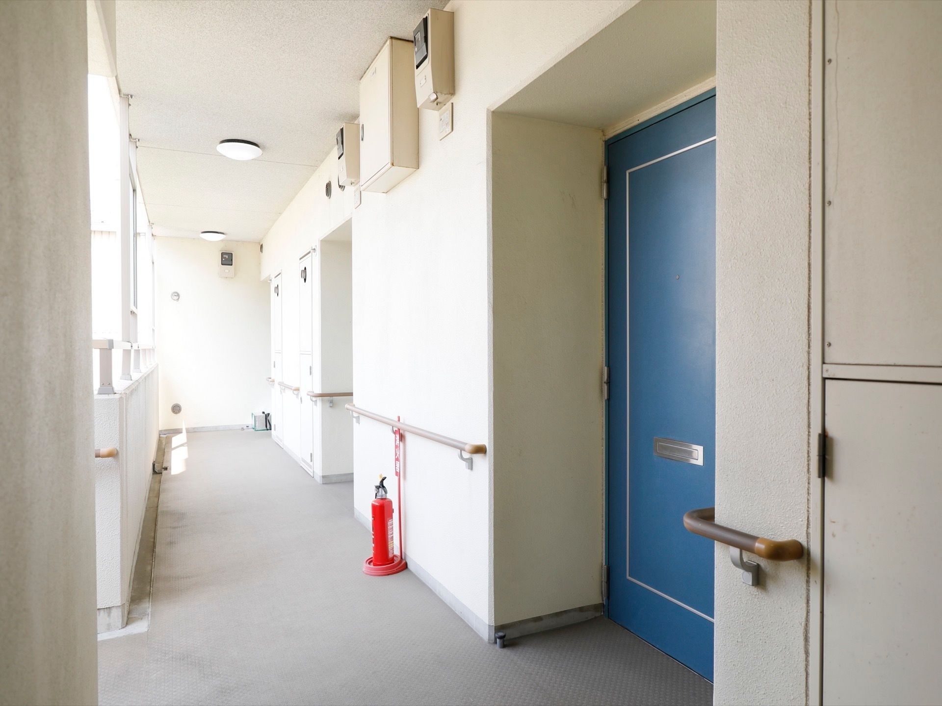 居室や各設備をつなぐ廊下は、基本的に外に面している。天井付近には配電盤やブレーカーなどが設置されている。