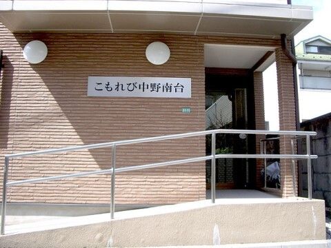 紙を使ったレクリエーションをする高齢女性と女性スタッフ
