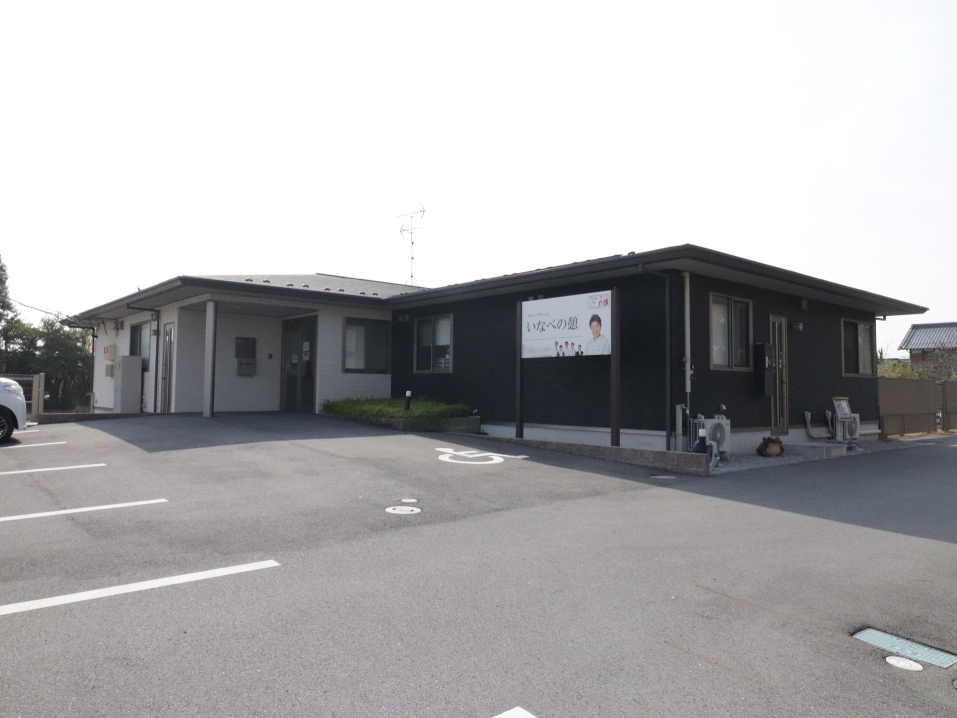 広い敷地に建っている平屋建ての施設である。駐車スペースが建物前に設けられている。エントランス近くに花壇がある。