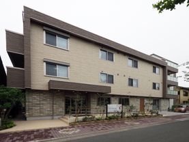 建物の造りが四角くなっているので外から見るととてもシックでおしゃれに見える。玄関前には手すりがある。
