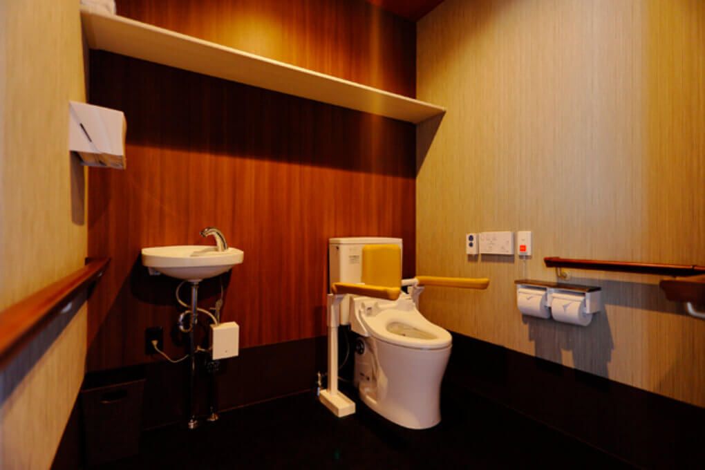 シックで高級感のあるトイレである。便器には手摺が設置してある。また、腰壁にも手摺が回してあるため、移動の際安心出来る。